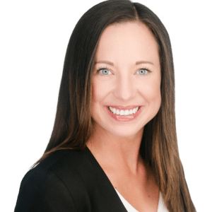 A woman smiling in a professional headshot, wearing a black blazer and white top.